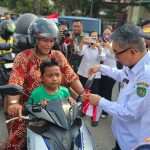 Bupati Kutim, Ardiansyah Sulaiman bagikan bendera ke pengguna jalan. (Ist)