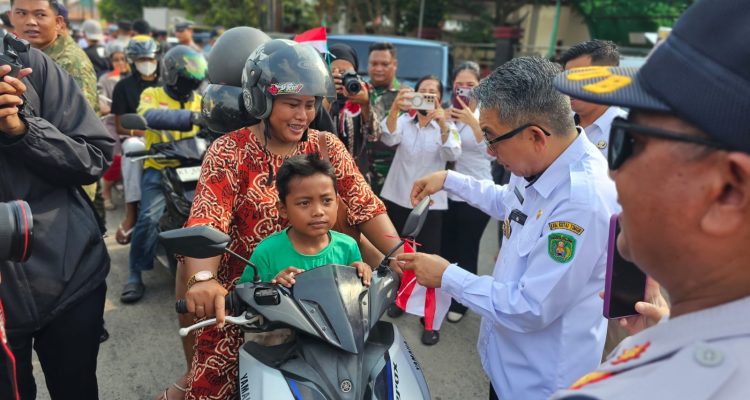 Bupati Kutim, Ardiansyah Sulaiman bagikan bendera ke pengguna jalan. (Ist)