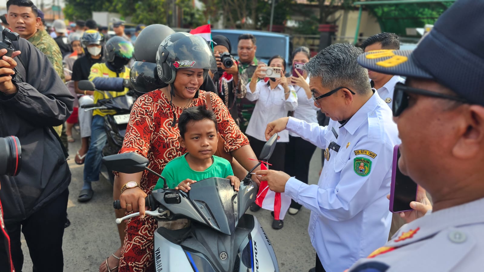 Bupati Kutim, Ardiansyah Sulaiman bagikan bendera ke pengguna jalan. (Ist)